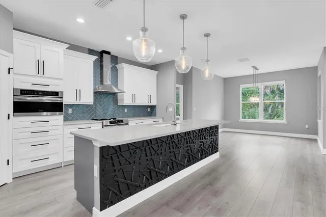a kitchen with stainless steel appliances kitchen island granite countertop a sink and a refrigerator