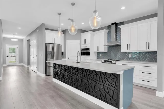 a kitchen with kitchen island granite countertop a sink stainless steel appliances and cabinets