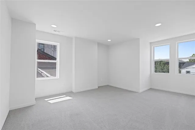 an empty room with closet and windows