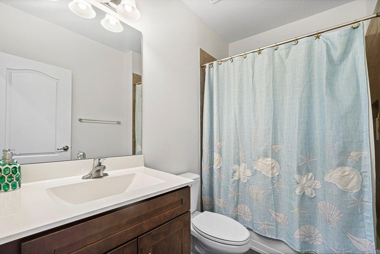 12949 Anthorne Lane Boynton Beach, FL 33436 - Photo 22 of 37 a bathroom with a sink a toilet and shower curtain