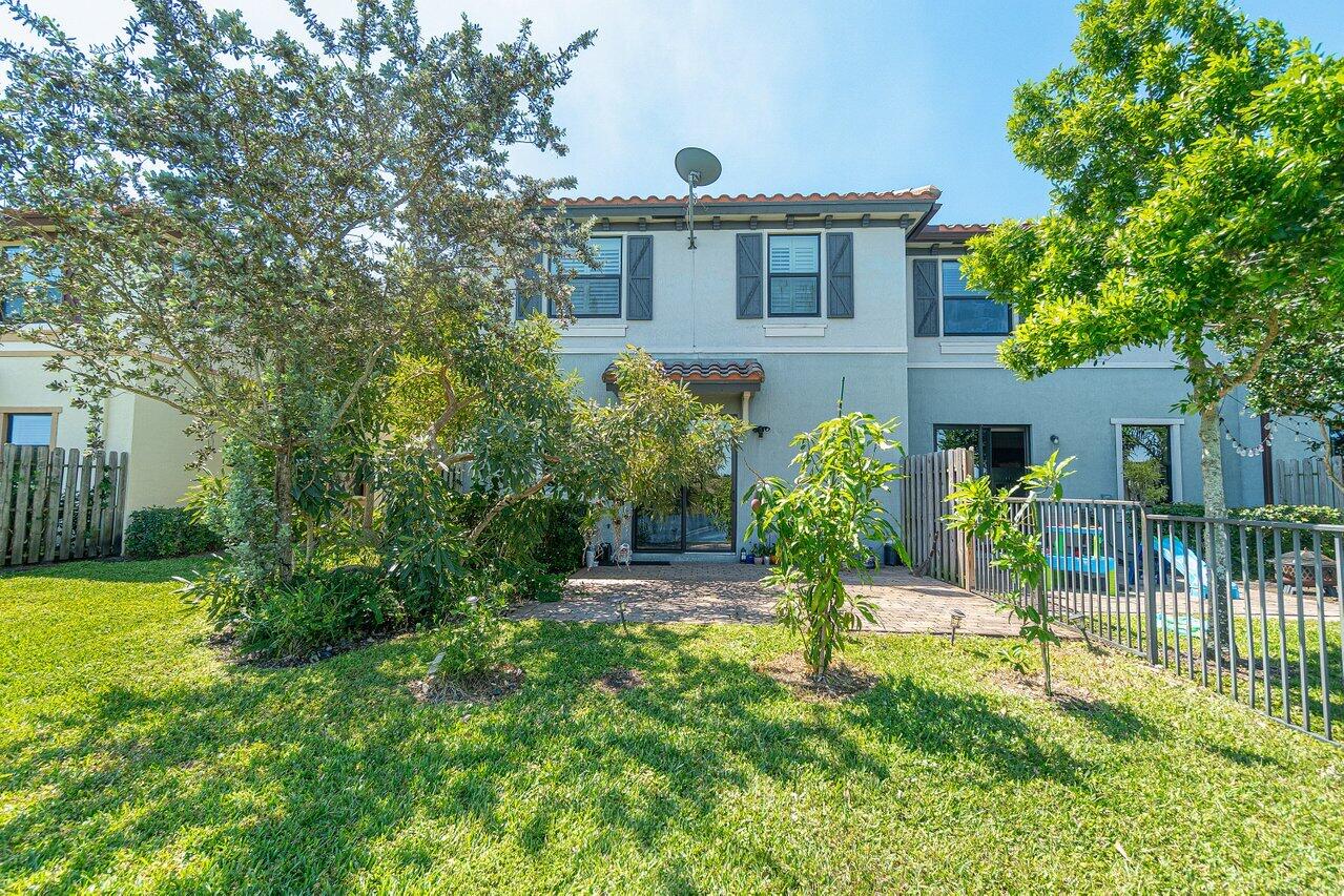 12949 Anthorne Lane Boynton Beach, FL 33436 - Photo 30 of 37 a view of a house with a yard and a garden