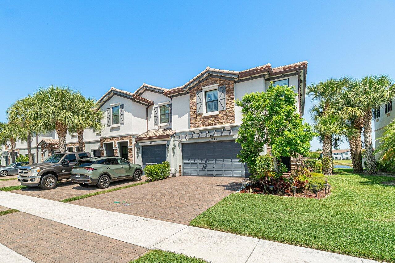 12949 Anthorne Lane Boynton Beach, FL 33436 - Photo 3 of 37 a front view of a house with a garden and car parked