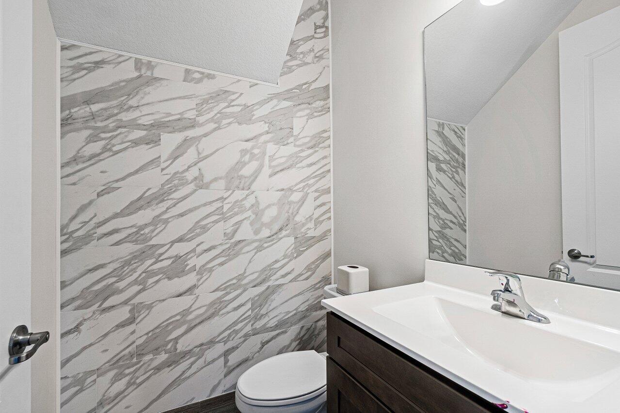 12949 Anthorne Lane Boynton Beach, FL 33436 - Photo 5 of 37 a bathroom with a sink a toilet a mirror and shower curtain