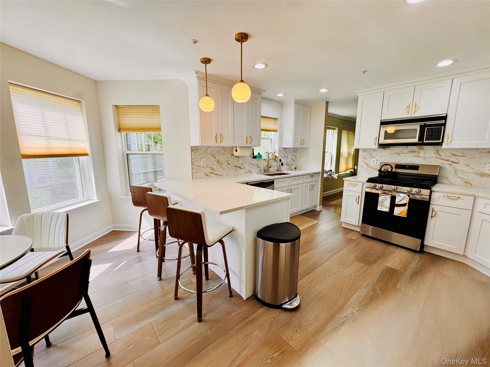121 Winding Ridge Road White Plains, NY 10603 - Photo 5 of 43 a kitchen with stainless steel appliances granite countertop a stove top oven a sink dishwasher a dining table and chairs with wooden floor
