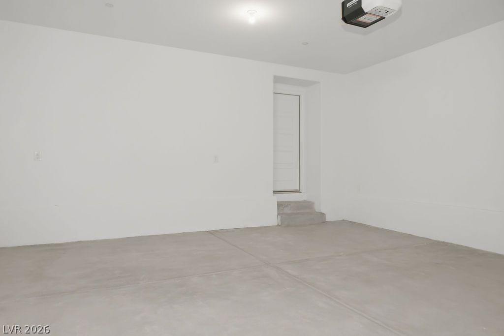 913 Cadence View Way Henderson, NV 89011 - Photo 38 of 46 A spacious and pristine garage provides ample parking and storage, featuring an accessible entry door.