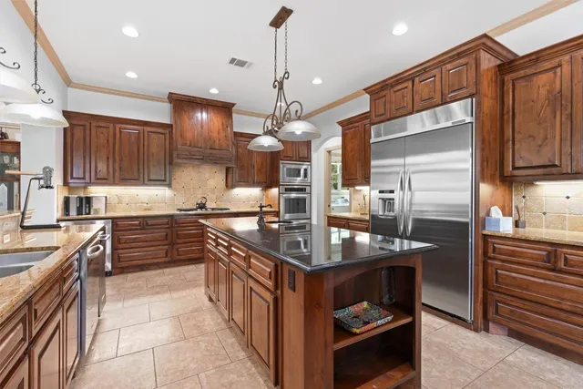 a kitchen with kitchen island granite countertop a sink a counter and cabinets