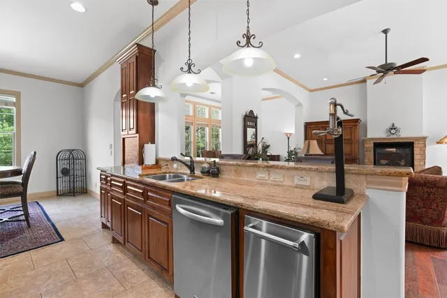 a view of a patio with couches table and chairs under an umbrella with a fire pit