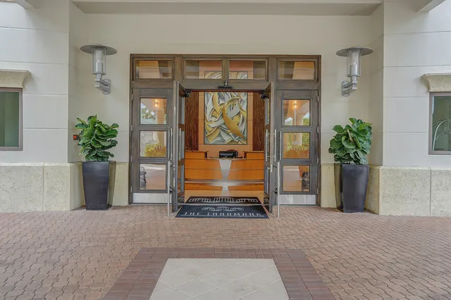 an empty room with a chandelier fan and windows