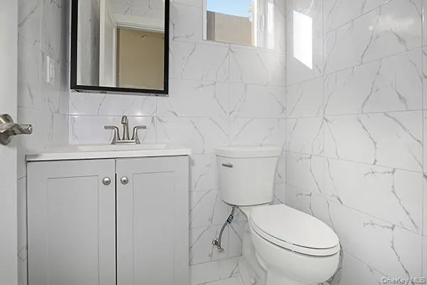 a bathroom with a toilet sink vanity and mirror
