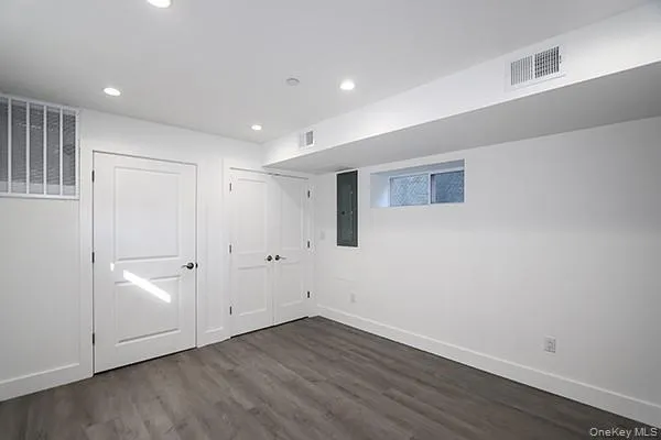a view of an empty room with wooden floor and closet