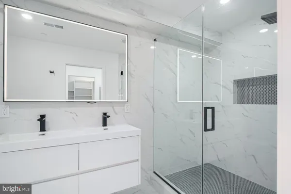 a bathroom with a shower sink and mirror
