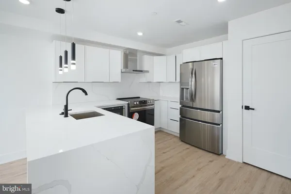 a kitchen with a refrigerator sink and cabinets