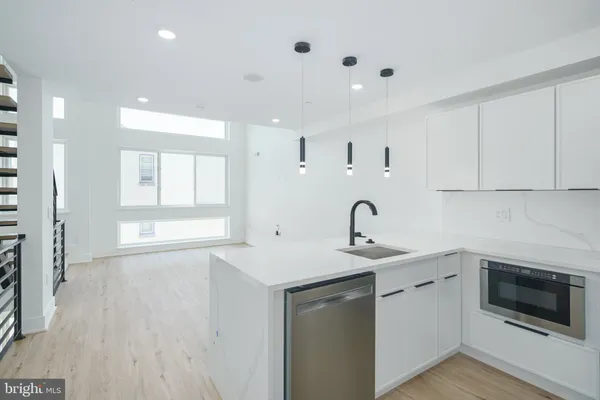 a kitchen with white cabinets appliances and sink