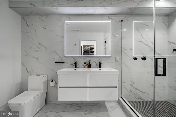 a bathroom with a bathtub sink mirror and toilet
