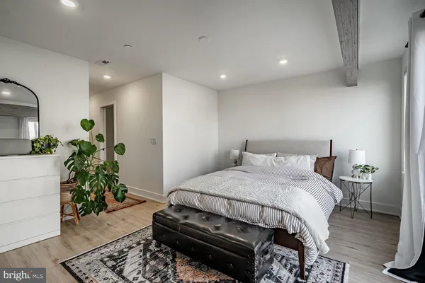 a bedroom with a bed table and a potted plant