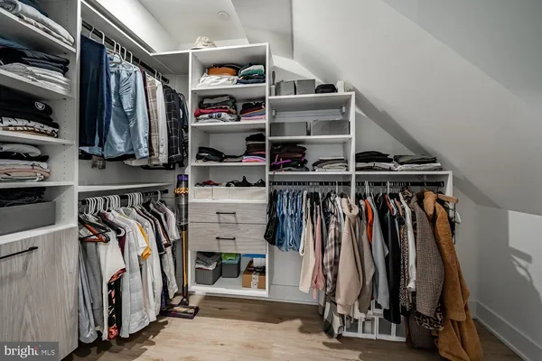 a view of walk in closet with clothes and shoes