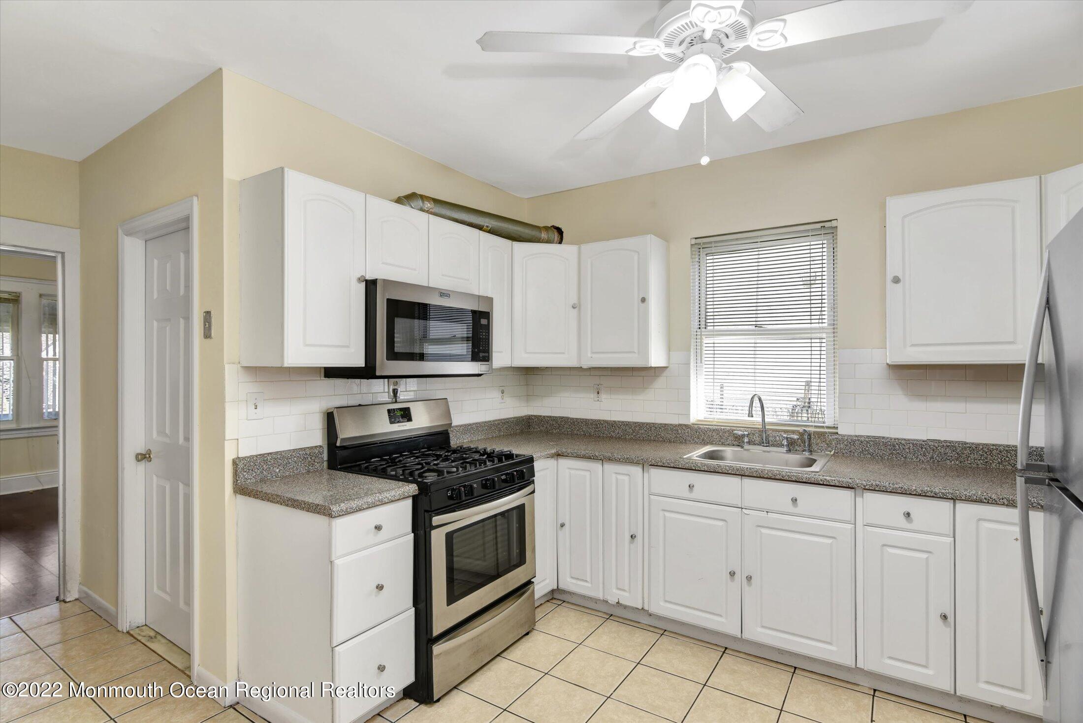 742 Old Road Elizabeth, NJ 07202 - Photo 11 of 25 a kitchen with granite countertop white cabinets stainless steel appliances and a sink