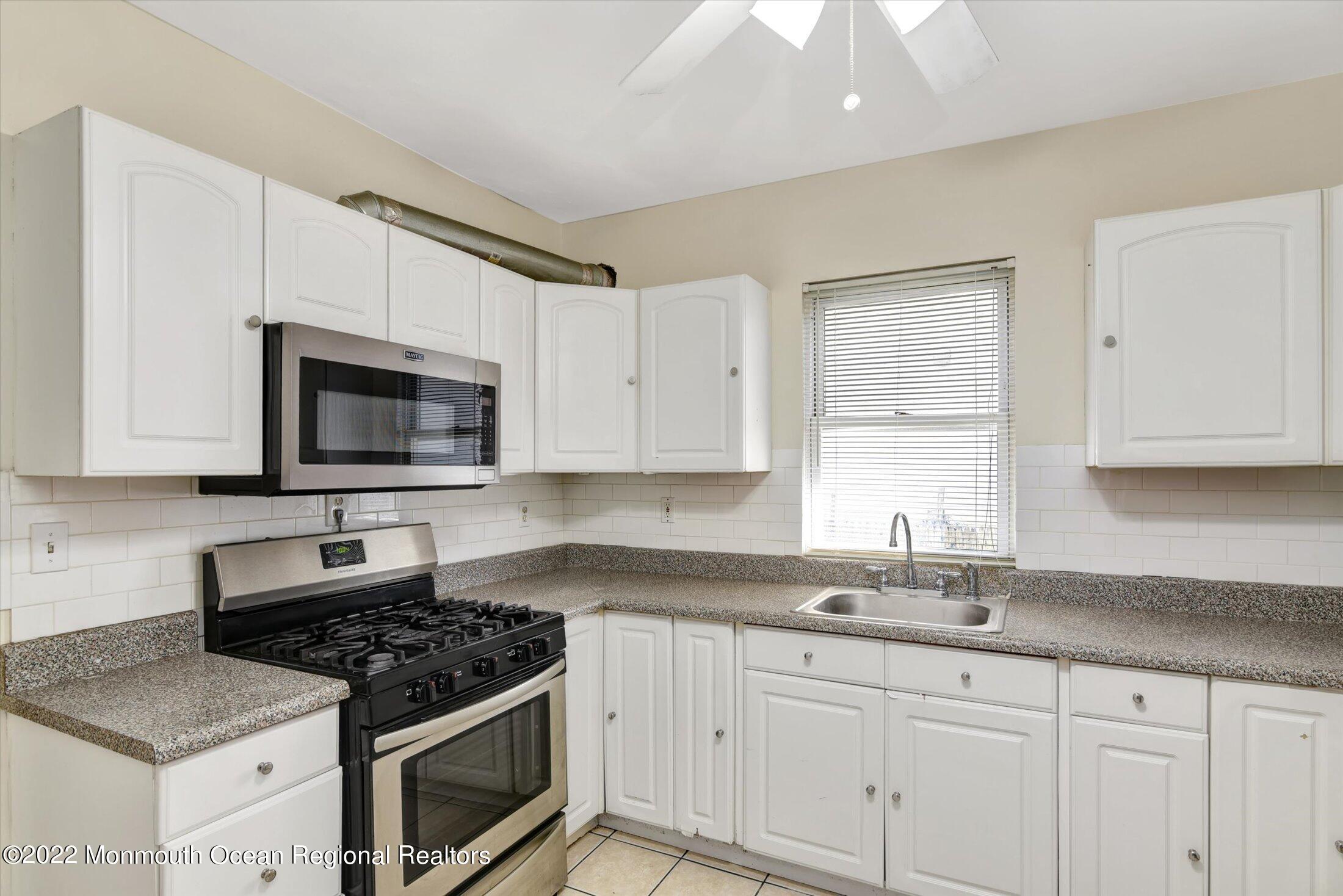 742 Old Road Elizabeth, NJ 07202 - Photo 10 of 25 a kitchen with granite countertop white cabinets stainless steel appliances and a sink