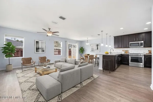 a view of kitchen with stainless steel appliances granite countertop a stove top oven a sink and a microwave