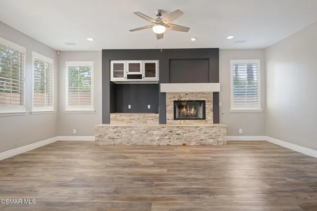 a view of empty room with wooden floor and fireplace