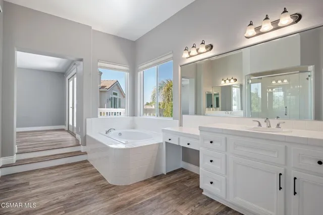 a white bath tub sitting in a bathroom next to a window