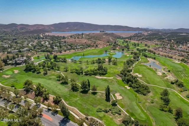 an aerial view of residential houses with outdoor space and trees