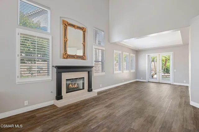 wooden floor fireplace and windows in an empty room