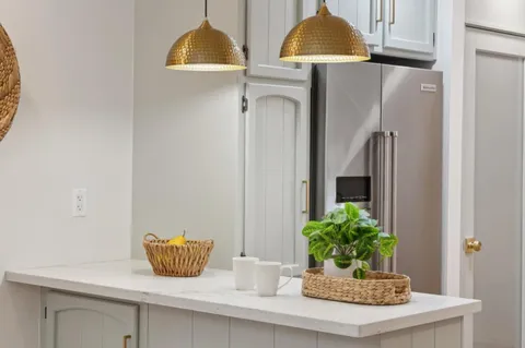a kitchen with granite countertop a refrigerator a sink and cabinets