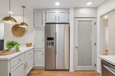 a kitchen with a sink refrigerator and cabinets