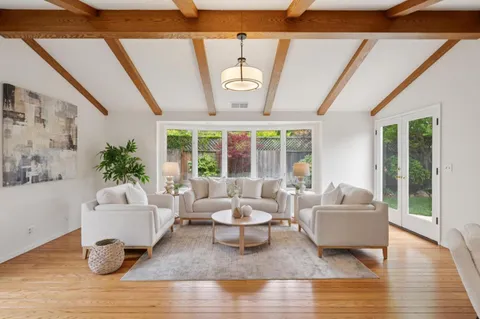 a living room with furniture and floor to ceiling windows