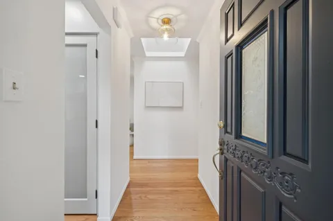 a view of a hallway with two mirror and a window