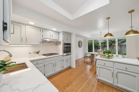 a kitchen with a sink stove and wooden cabinets