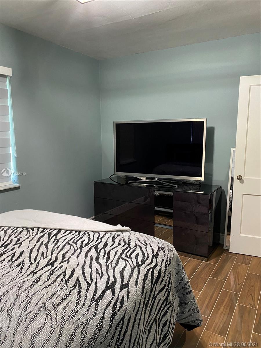 7565 Southwest 28th Street Road Miami, FL 33155 - Photo 19 of 31 a bedroom with a bed and a flat screen tv