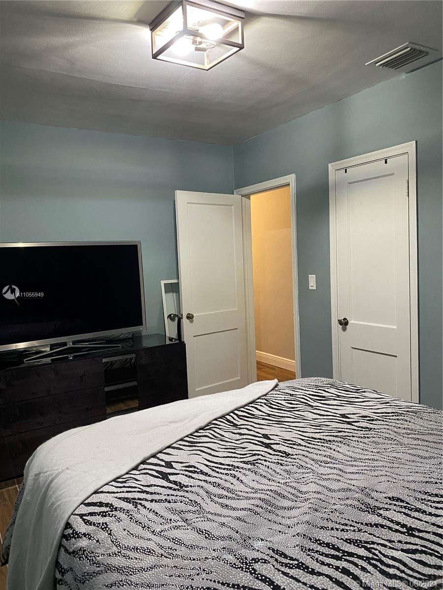 7565 Southwest 28th Street Road Miami, FL 33155 - Photo 20 of 31 a bedroom with a bed and a flat screen tv