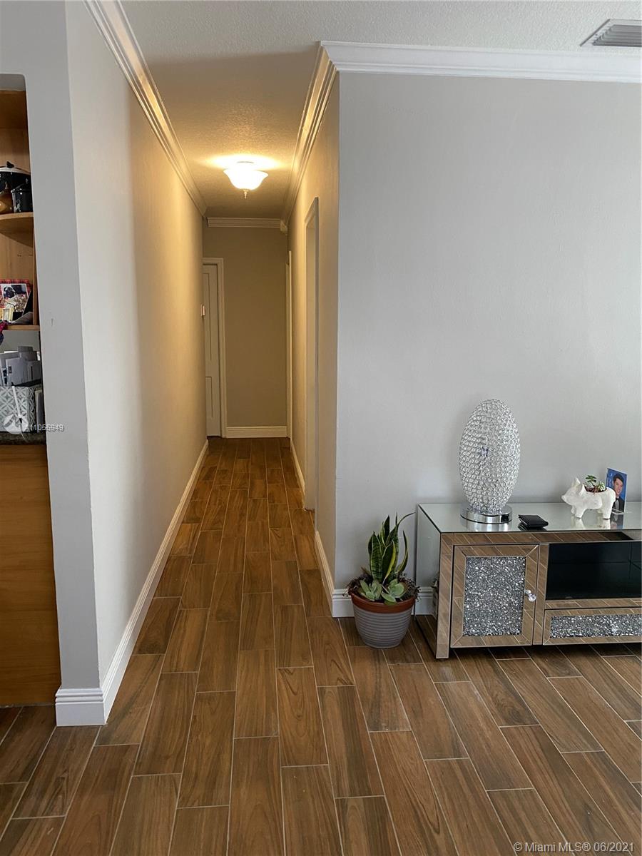 7565 Southwest 28th Street Road Miami, FL 33155 - Photo 6 of 31 a view of a hallway to room with wooden floor