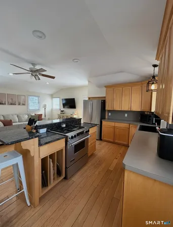 a kitchen with stainless steel appliances a stove top oven a sink a refrigerator and cabinets