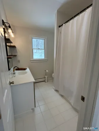 a living room with stainless steel appliances granite countertop furniture wooden floor and a kitchen view