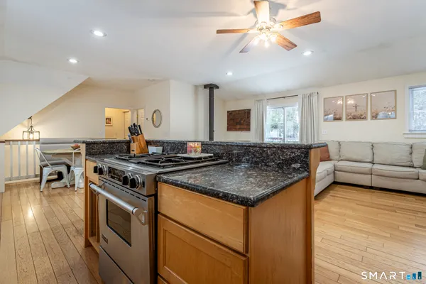 a living room with furniture and kitchen view with wooden floor