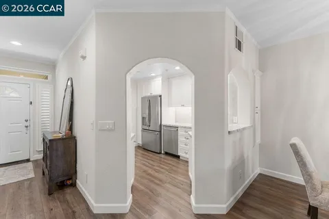a view of a hallway with wooden floor and furniture