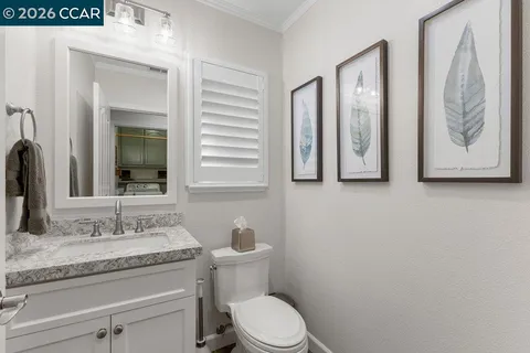 a bathroom with a granite countertop toilet sink and mirror