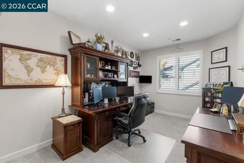 a view of a workspace with furniture and a window