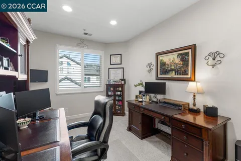 a view of a workspace with furniture and a window