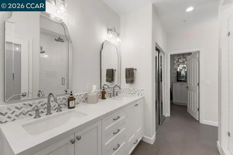 a bathroom with double vanity sinks and a mirror