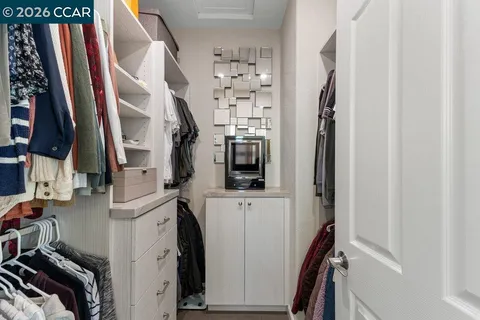 a view of walk in closet with clothes and shoes