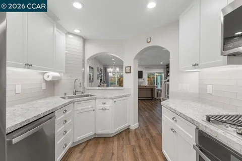 a kitchen with granite countertop a sink stainless steel appliances and cabinets