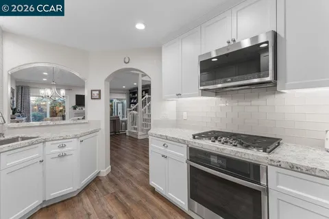 a kitchen with stainless steel appliances kitchen island granite countertop a stove a sink and a microwave