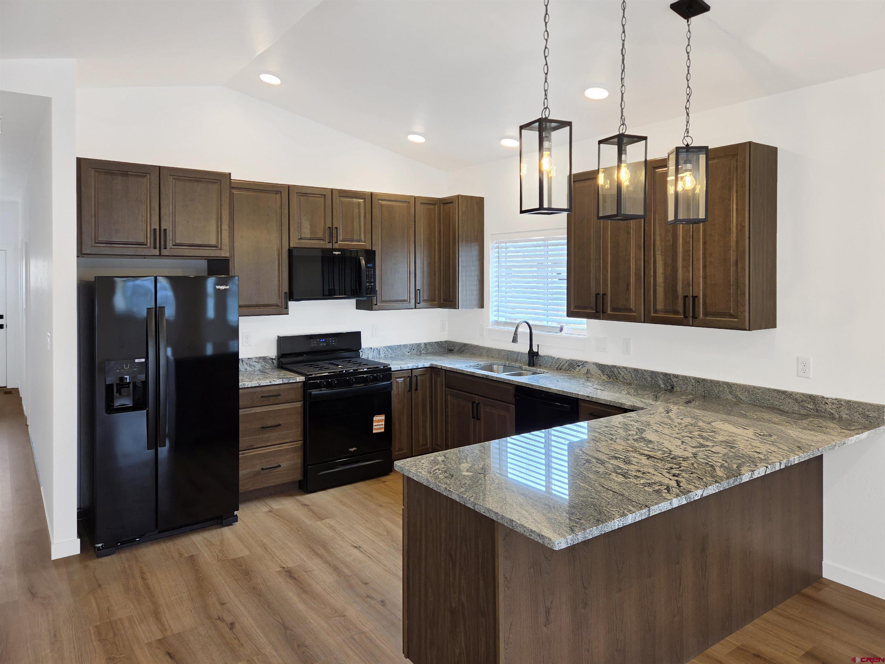 1456 Acoma Street Cortez, CO 81321 - Photo 5 of 26 a kitchen with stainless steel appliances granite countertop a refrigerator a sink a stove and oven