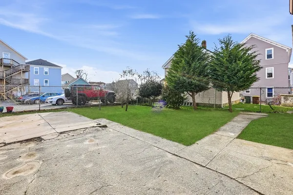 front view of a house with a yard and potted plants