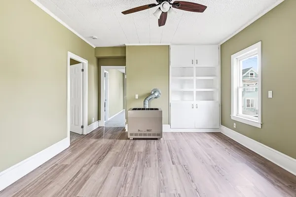 a view of a hallway with wooden floor and a bathroom