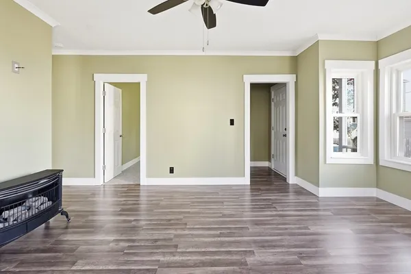 a view of an empty room and window with wooden floor
